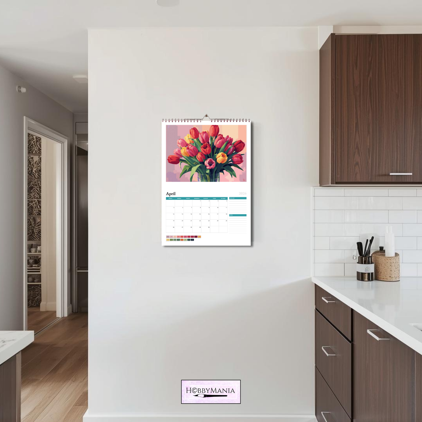 Lifestylefoto van de HobbyMania Kleuren Op Nummer Kalender 2026 opgehangen in een moderne keuken.